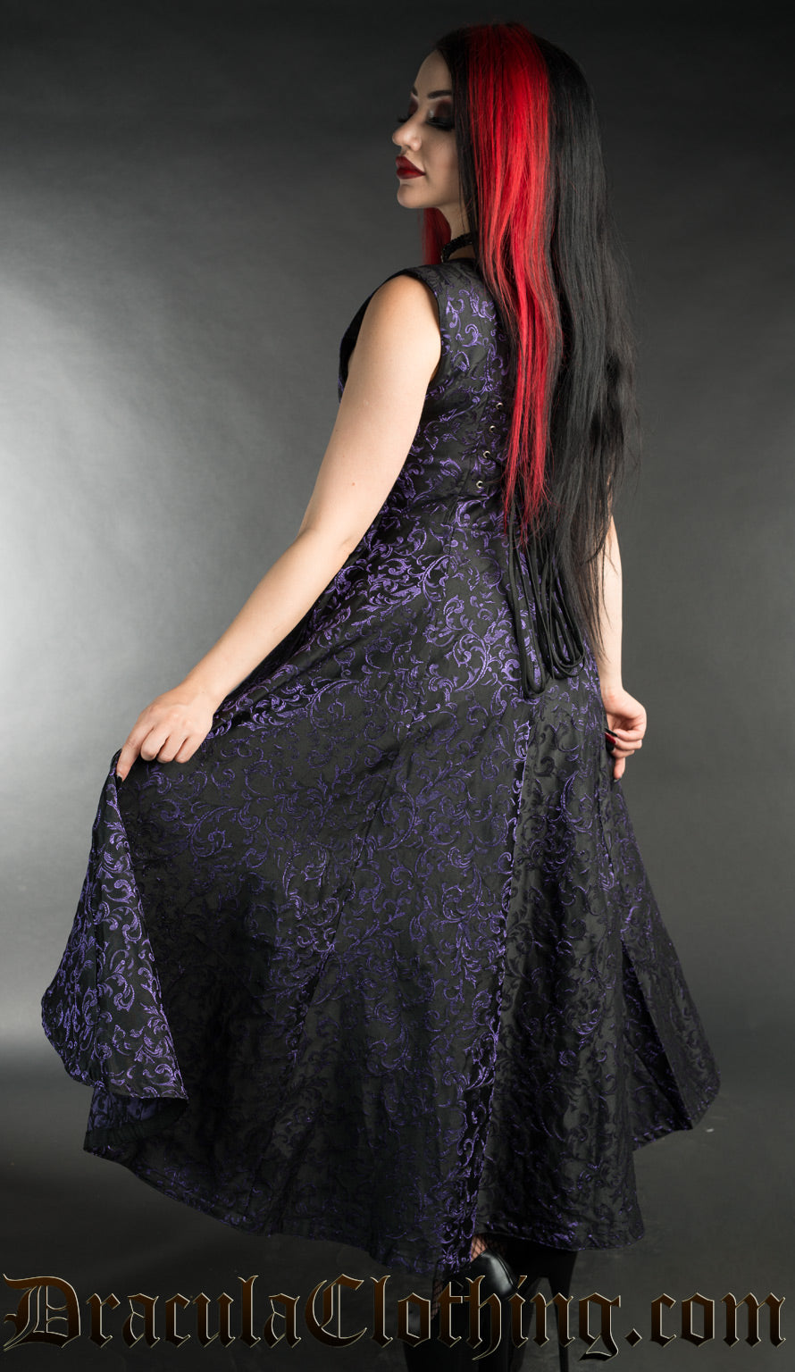 Back view of women's purple brocade dress showing adjustable lacing in the torso and longer skirt in the back than front