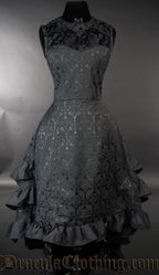 Front view of women's black brocade bustle dress showing the front of the skirt lowered