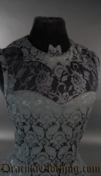 Close up of bat shaped collar and sheer lace illusion chest panel on women's dress made with black cotton brocade fabric in a damask pattern