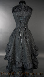Back view of women's black brocade bustle dress showing adjustable corset style lacing in the torso and layered skirt tiers