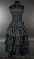 Back view of women's black brocade dress with layered skirt and lace back panel showing adjustable corset style lacing 