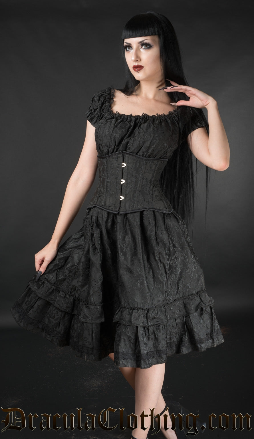 Women's black brocade knee length dress with stretchy bust worn by a model with matching waist cincher