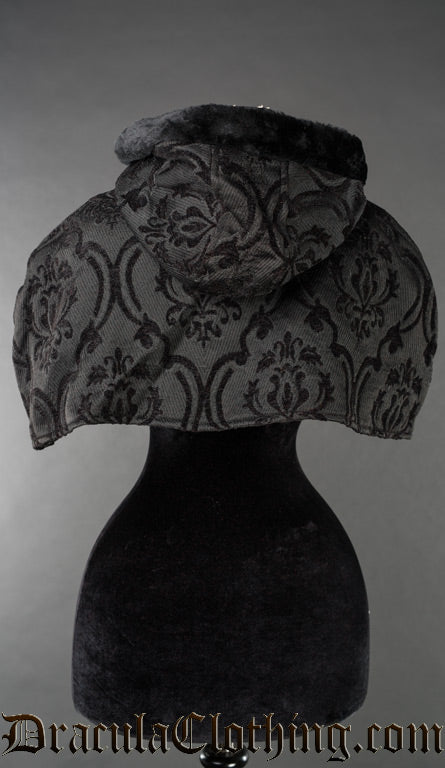 Back view of women's attachable hood and cape made with black brocade thick jacquard fabric and black faux fur
