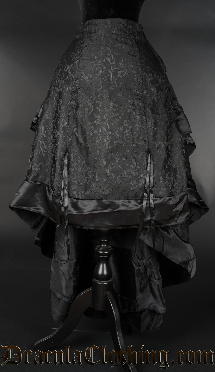 Black brocade bustle skirt shown lowered in the front