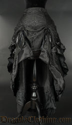 Women's black layered bustle skirt made from brocade fabric and black satin lining shown raised in the front with two strings