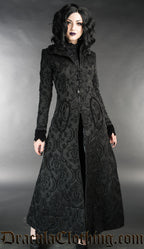 Long women's fitted black coat with knot fastening made from thick black brocade fabric in a damask pattern