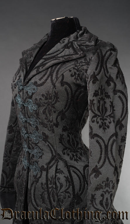Close up side view of women's black brocade coat showing collar details and fabric's damask style woven pattern