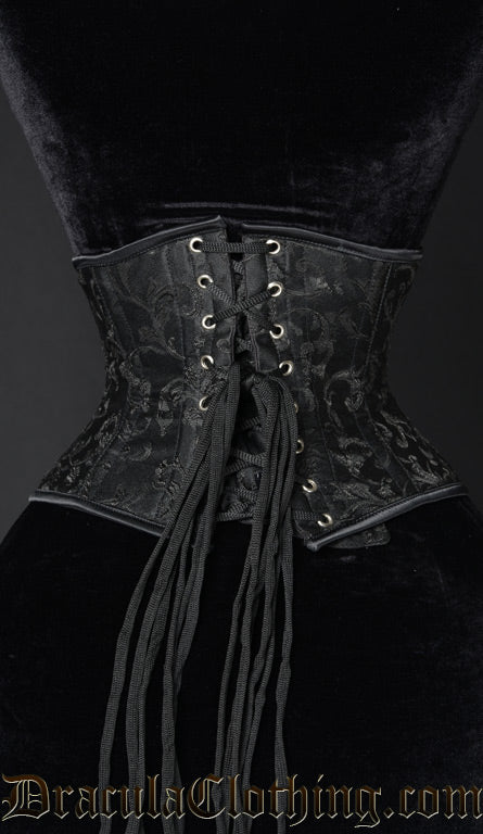 Back view of black waist cincher with woven black brocade details showing adjustable corset lacing