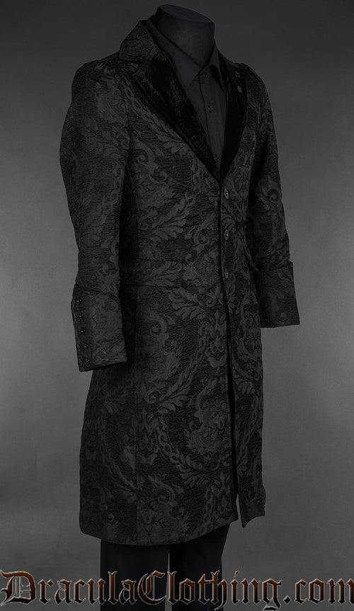 Long black chenille brocade coat with black velvet shawl lapels and a three-button front, displayed on a mannequin over a black shirt. side view