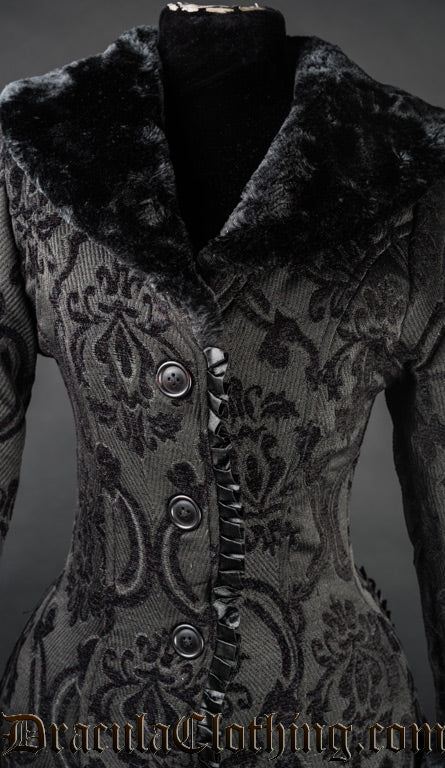 Close up of faux fur collar and ruffled satin trim on women's black brocade coat