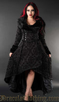 Model wearing women's high low winter coat made with brocade jacquard fabric in a black on black damask pattern and faux fur accents