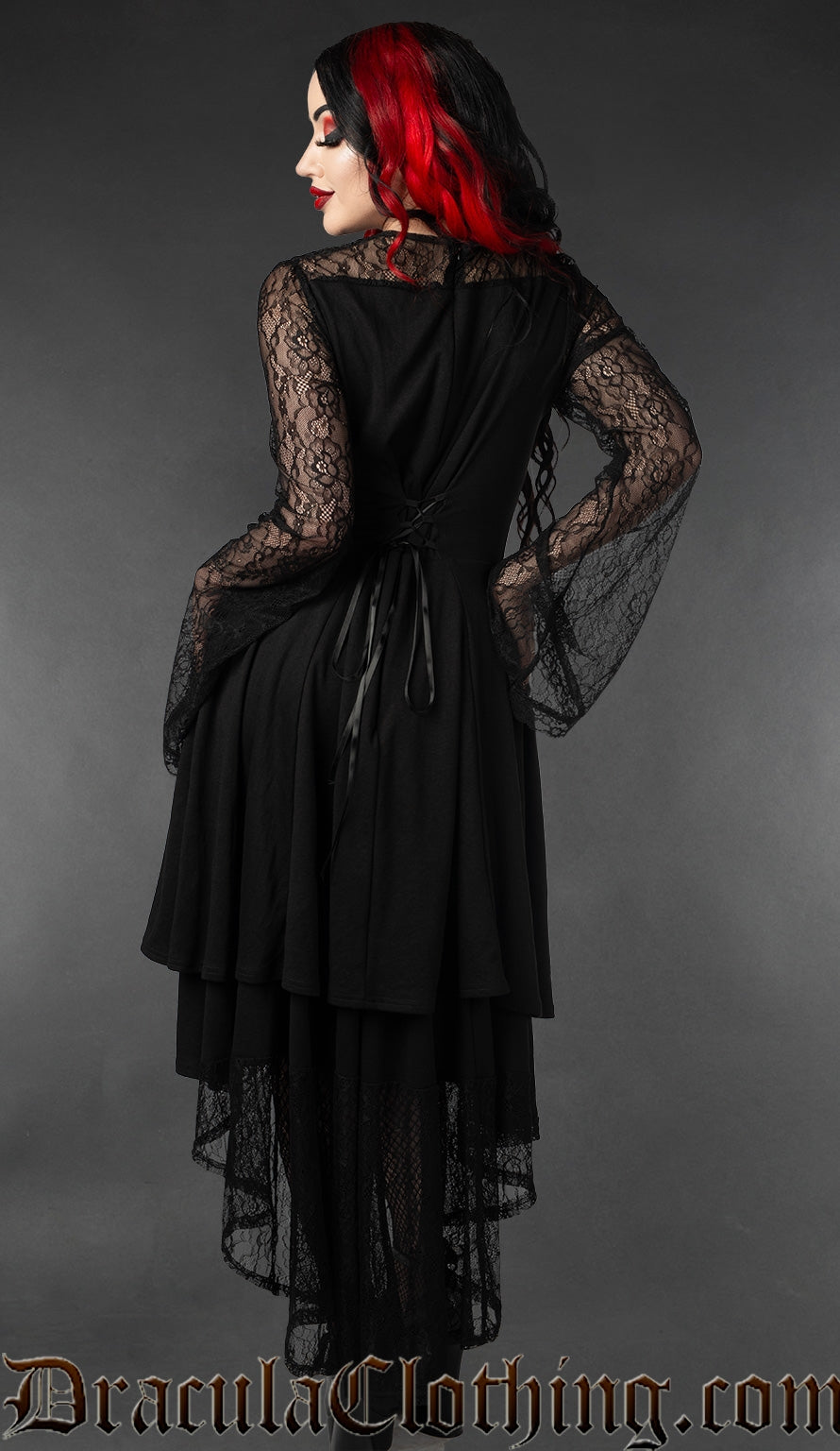 Back view of women's black lace high low dress with sheer lace trumpet style sleeves showing adjustable corset style lacing in torso
