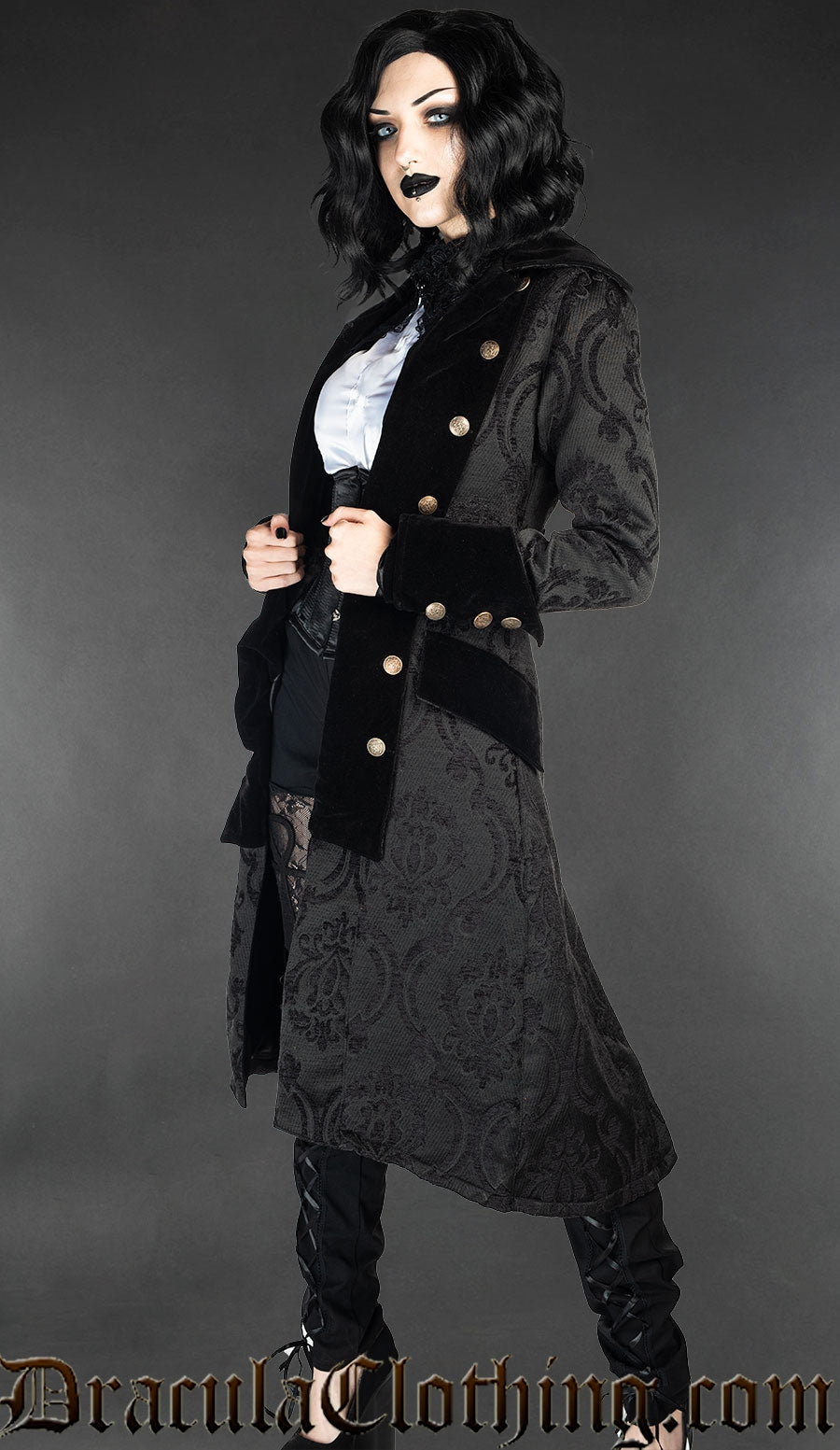 Model wearing women's black pirate inspired coat with velvet accents and decorative buttons