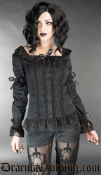 Model wearing black long sleeved blouse with a square neckline and lace details. Sleeves have a flared lace cuff and additional bows