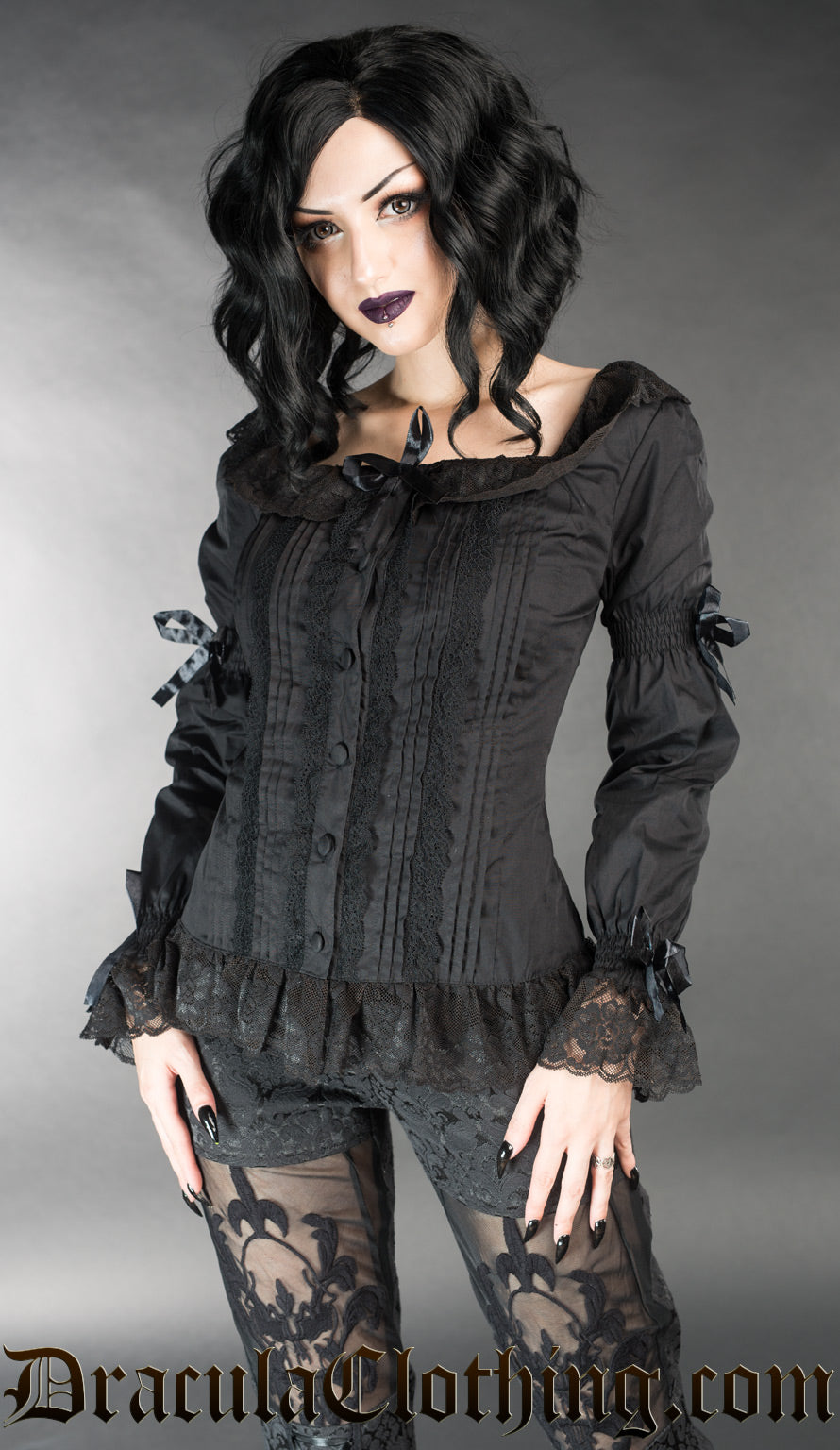 Model wearing black blouse with long sleeves and squared neckline