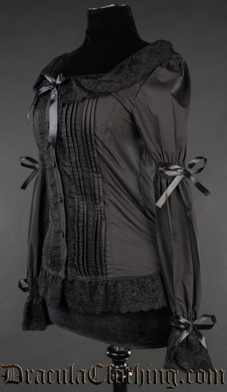 Side view of black blouse showing pleated design on the front and ribbon bows on the sleeves