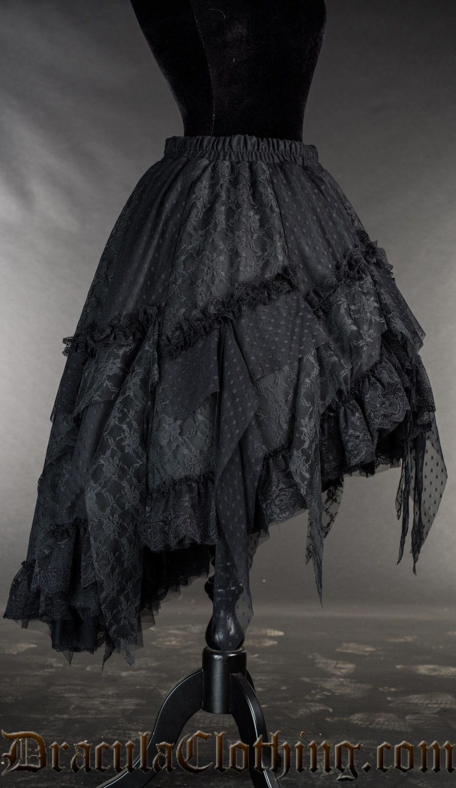 Side view of women's black satin and lace ruffle skirt showing high low style of shorter in the front than the back