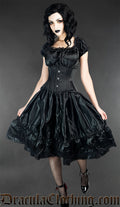 Women's knee length sleeveless black satin dress with lace details worn by a model with additional matching waist cincher