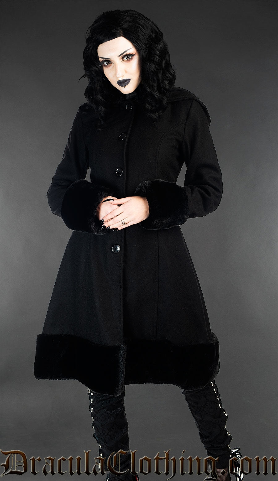 Hood down view of women's winter coat made from black wool and faux fur trim