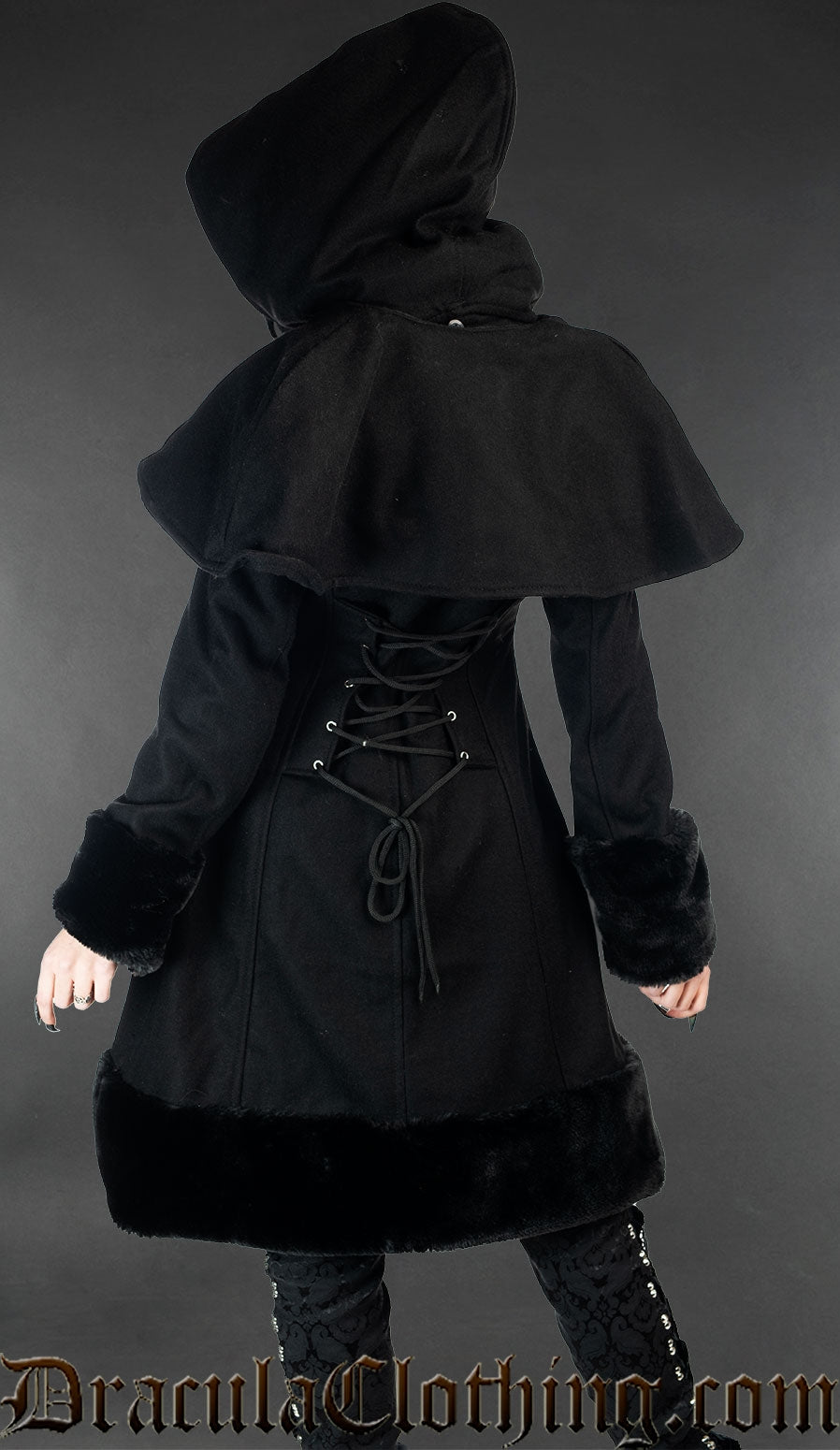 Back view of women's black winter wool coat showing adjustable corset-style lacing and removable cape