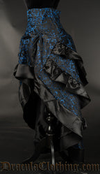 Side view of women's blue brocade bustle skirt showing high low style and three layers in the back for volume