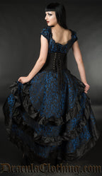 Women's blue brocade layered bustle skirt shown from the back displaying three layers each with black satin ruffled hem