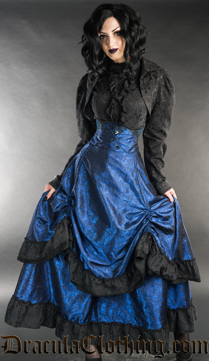 Women's high waisted blue bustle skirt with black brocade accents at the hem of each layer and buttons at the waist