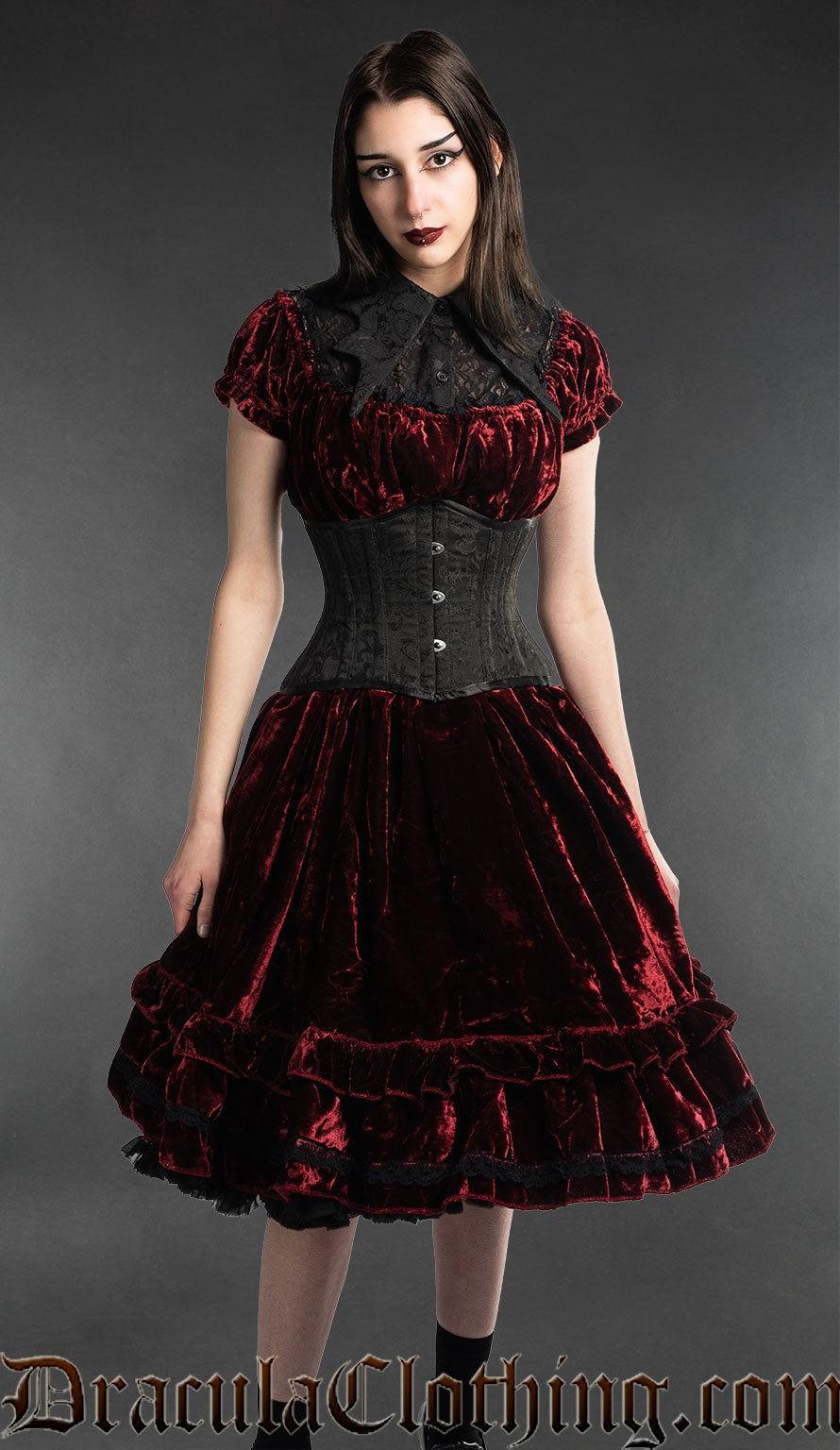 Model wearing women's red knee-length velvet dress with waist cincher and collar