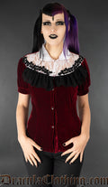Model wearing deep red velvet blouse with white and black lace details