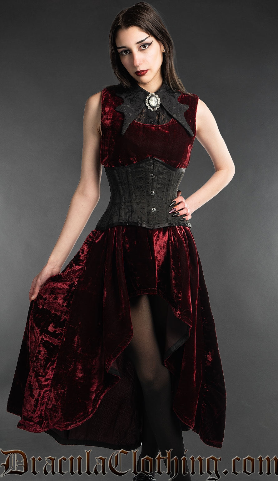 Model wearing red velvet dress with black collar and black waist cincher
