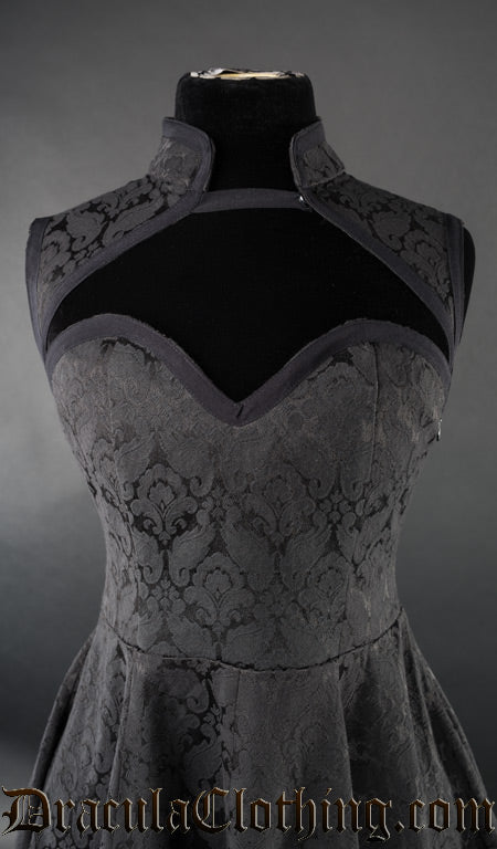 Close up front view of women's black brocade dress showing queen anne style neckline and additional high collar