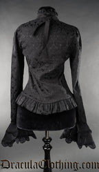 Back view of women's black brocade long sleeved blouse showing frilled hem and high collar