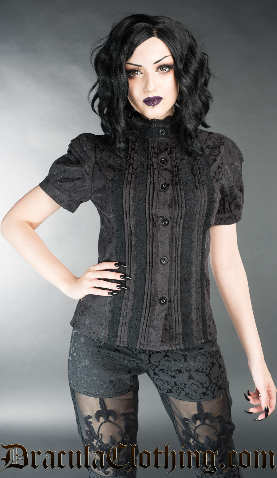 Women's black brocade short sleeve blouse with pleated design and lace details worn by model