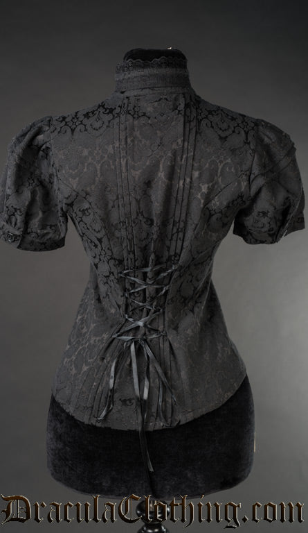 Back view of women's black brocade blouse showing adjustable lacing