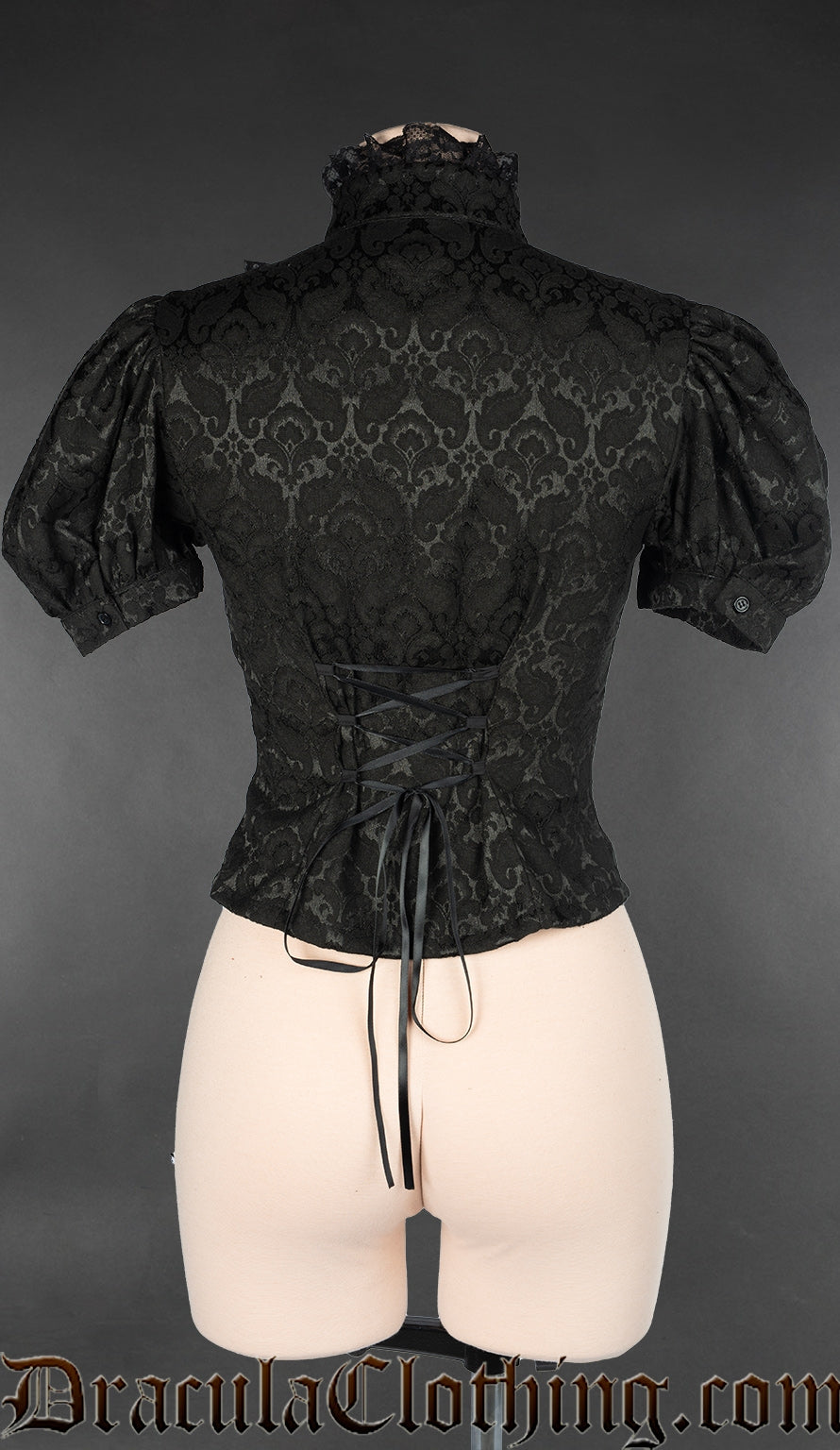 Back view of black brocade women's short sleeved blouse showing adjustable lacing and lace trim on high neck collar