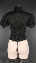 Back view of black brocade women's short sleeved blouse showing adjustable lacing and lace trim on high neck collar