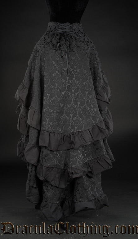 Back view of women's black brocade layered bustle skirt showing adjustable corset style lacing in the waist and black cotton hems on each layer