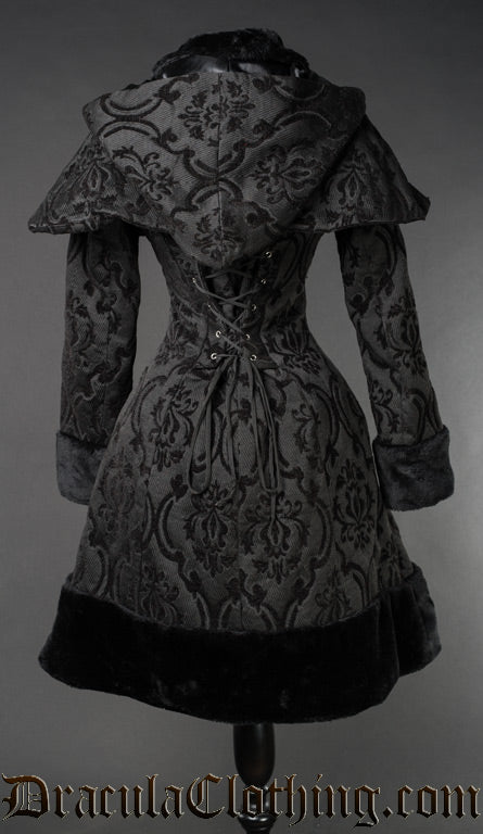 Back view of women's black jacquard coat showing attached hood and cape and adjustable corset style lacing