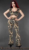 Black and gold gothic velvet flare pants with cherub and baroque print worn by a model