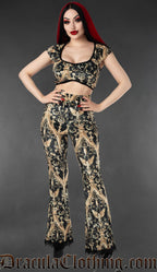 Black and gold gothic velvet flare pants with cherub and baroque print worn by a model