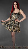 Model wearing a black and gold velvet skater dress with cherub and baroque print