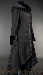 Side view of black cotton high low coat showing faux fur sleeve cuffs and black satin trim hem
