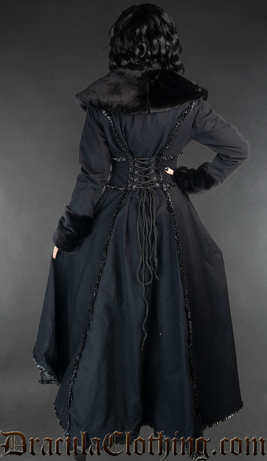 Back view of black cotton coat showing longer length in the back and adjustable corset style lacing in the torso