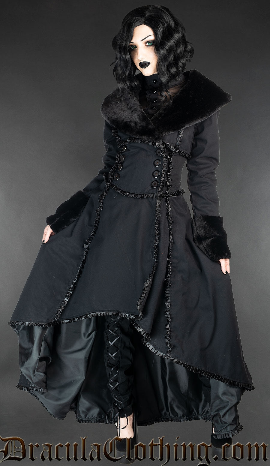 Model wearing black cotton coat with faux fur collar and sleeve cuffs, and satin lining and details