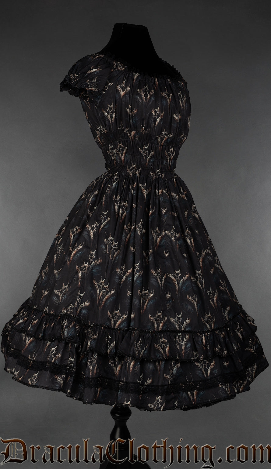 Side view of black knee length women's dress with dragon design showing elasticated sleeves and black lace details on the hem