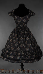 Back view of black women's dress with dragon print design showing very elasticated waist and black lace accents on skirt