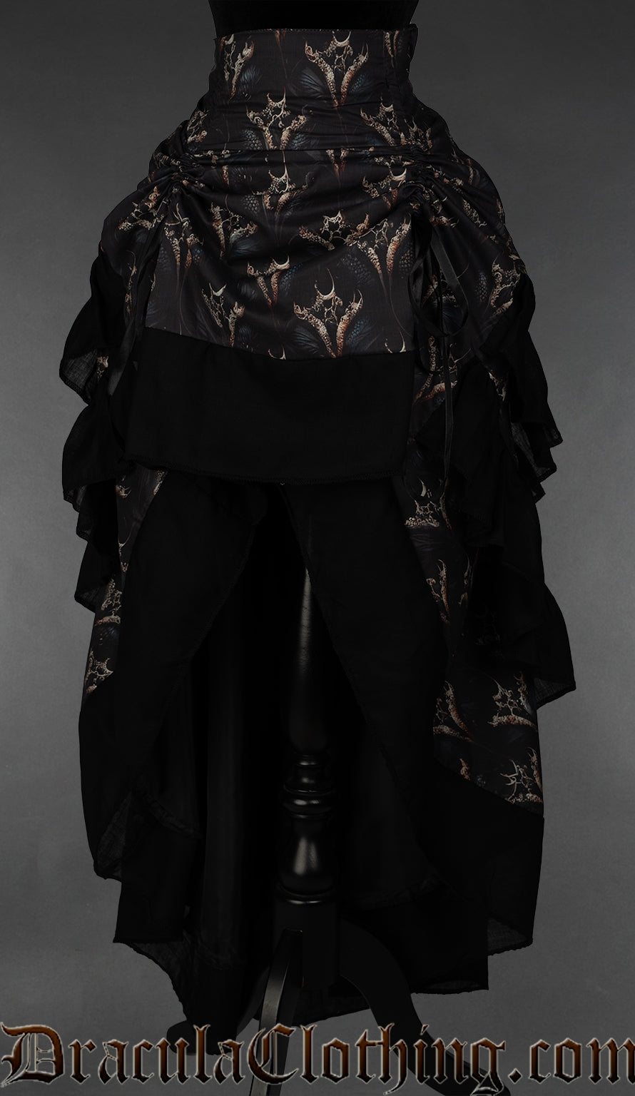 Women's layered bustle skirt featuring a dragon print on a dark background shown with the skirt raised in the front