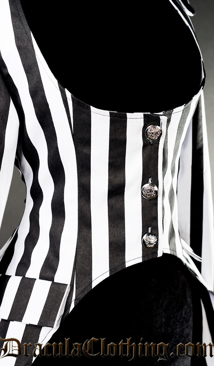 Close up of silver button fastening on the front of women's striped black and white openbust style coat