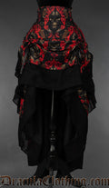 Women's layered bustle skirt with red and black ornate skull print and black cotton hem shown raised in the front