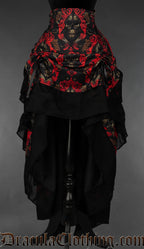Women's layered bustle skirt with red and black ornate skull print and black cotton hem shown raised in the front